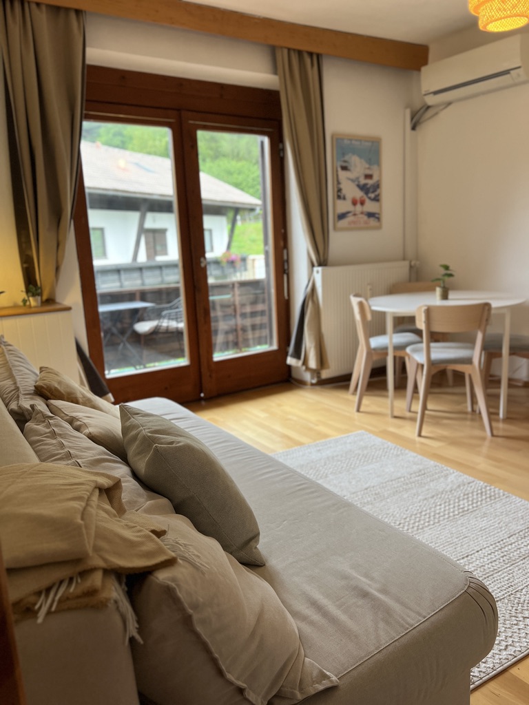Sofa and dining corner with ski poster and air conditioning