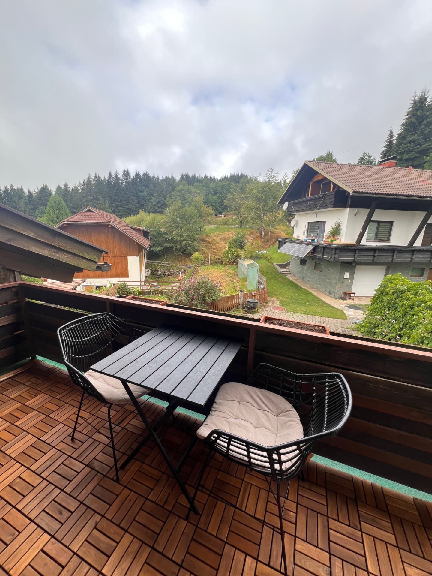 Wooden balcony deck with village and forest view