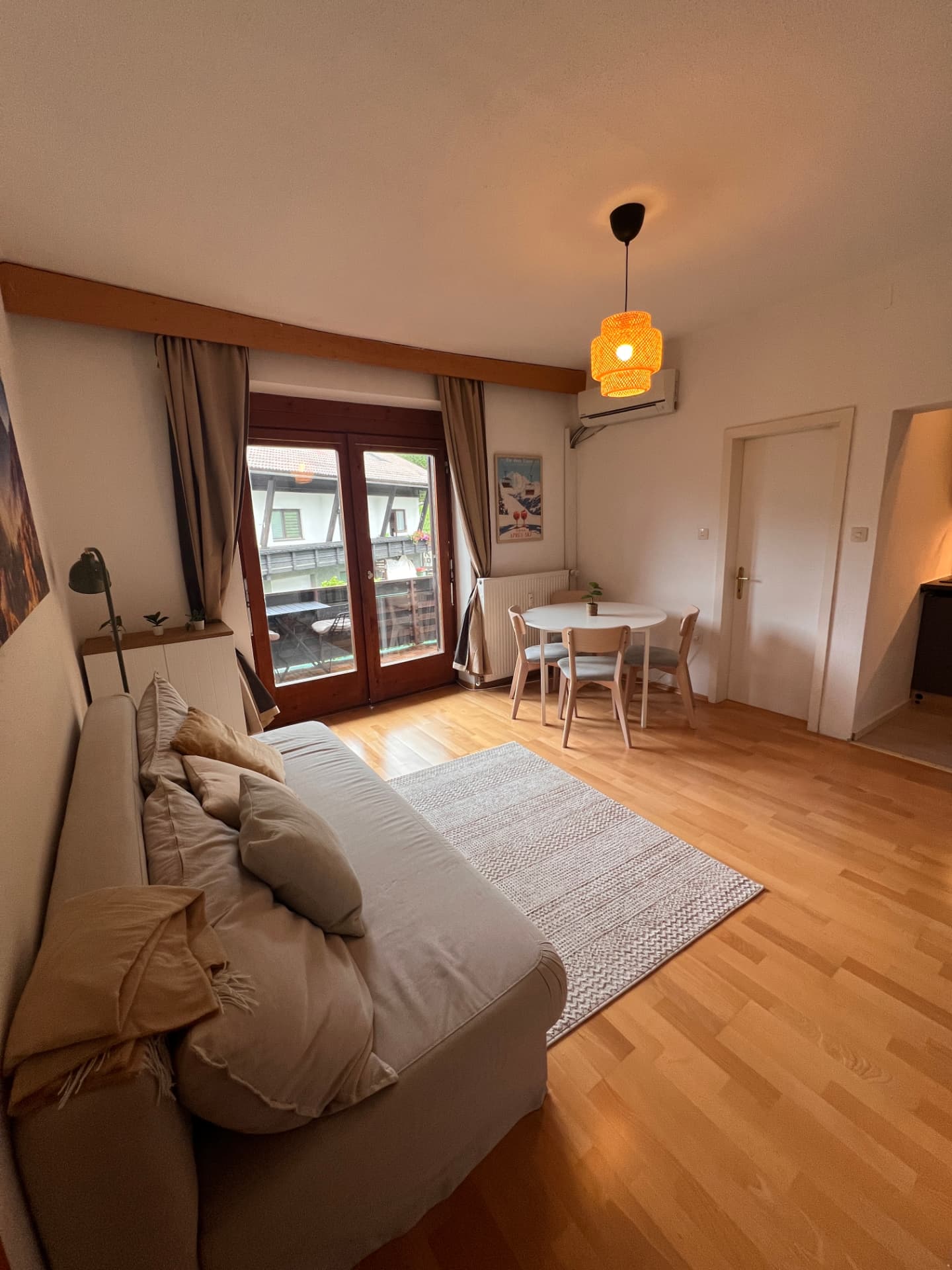 Living room with sofa bed, air conditioning and balcony access