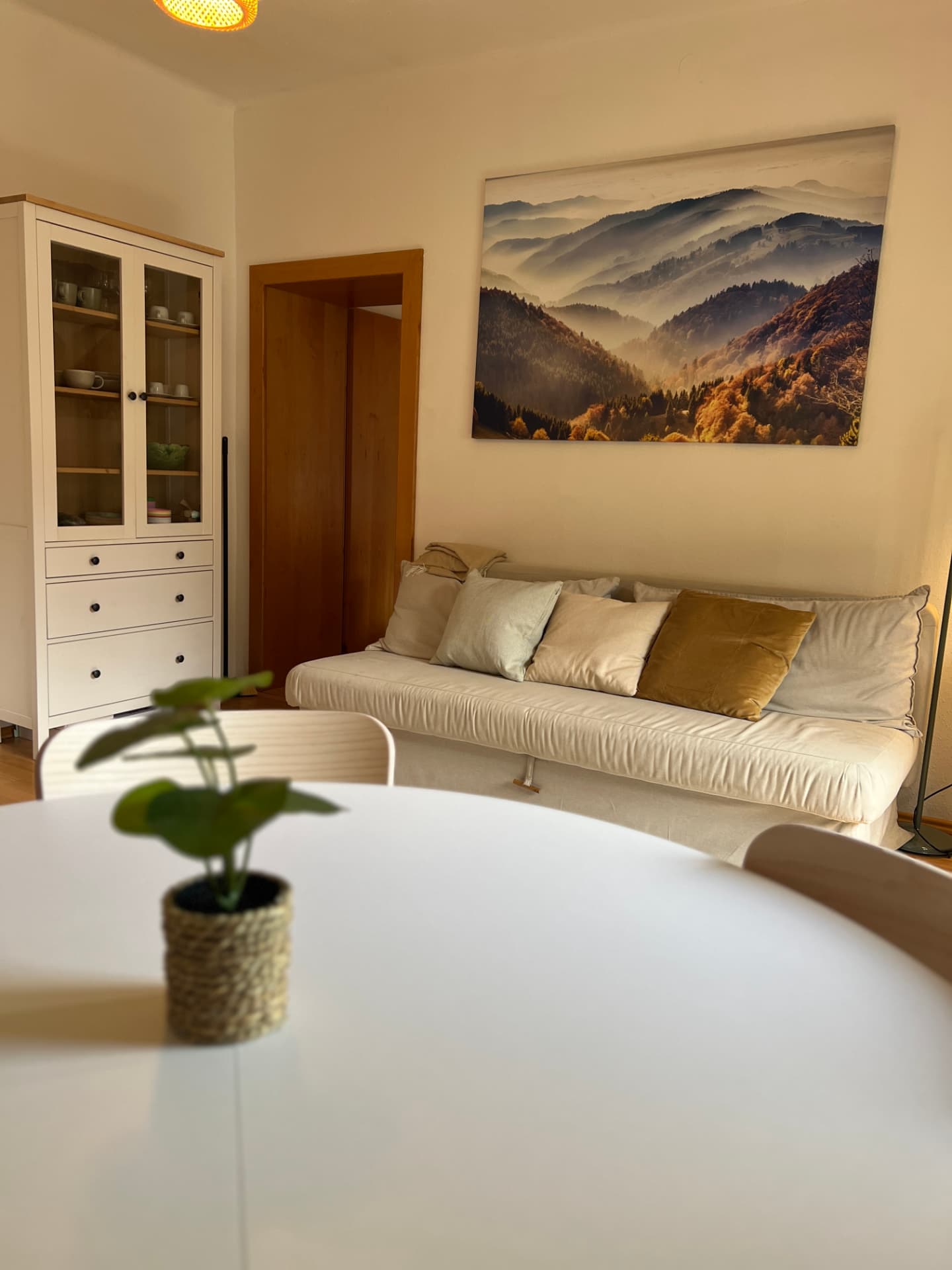 Seating area with mountain canvas print and glass cabinet