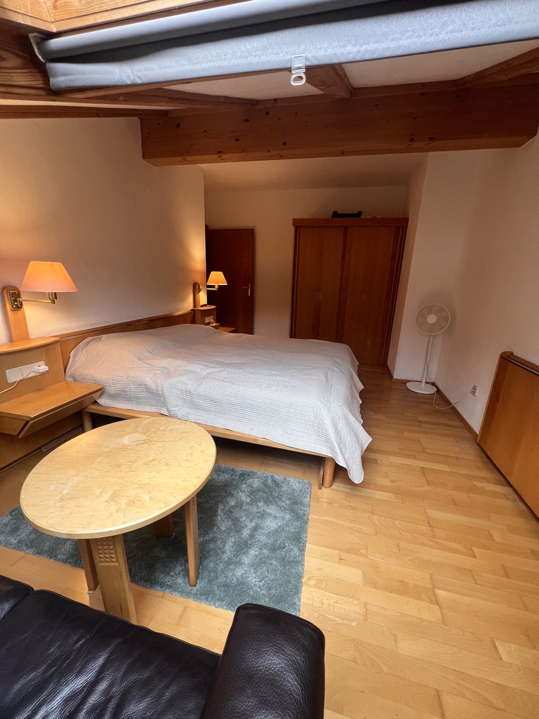Bedroom with double bed, wardrobe and round wooden table